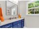 Modern bathroom featuring blue vanity, stylish mirror, stone countertop, and bright natural light at 2226 Arthur Rose Ln, Johns Island, SC 29455