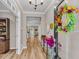 Inviting foyer with wood flooring, a console table with flowers, and a decorative wreath on the front door at 2226 Arthur Rose Ln, Johns Island, SC 29455