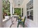 Relaxing front porch featuring stylish chairs with yellow pillows, hanging lights, and a view of the serene outdoors at 2226 Arthur Rose Ln, Johns Island, SC 29455