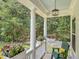 Cozy front porch with comfortable seating, flower boxes, and elegant lighting, overlooking a lush green landscape at 2226 Arthur Rose Ln, Johns Island, SC 29455
