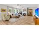 Cozy living room featuring a fireplace, hardwood floors, large windows, and comfortable seating arrangements at 2226 Arthur Rose Ln, Johns Island, SC 29455