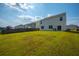 Spacious backyard with lush green grass, wooden fence, and view of the home's exterior at 225 N Light Way, Summerville, SC 29486