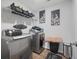 Well-equipped laundry room with gray washer/dryer, overhead shelving, decor, and wood-look flooring at 225 N Light Way, Summerville, SC 29486