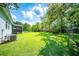 Well-manicured backyard with a screened porch, lush green lawn, and mature trees at 229 Lindy Creek Rd, Goose Creek, SC 29445