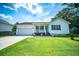 Inviting single-story home featuring a cozy front porch, an attached garage, and a well-maintained lawn at 229 Lindy Creek Rd, Goose Creek, SC 29445