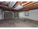 Unfinished basement featuring exposed wood beams and a garage door at 2320 Wofford Rd, Charleston, SC 29414