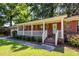 Charming brick home's entrance with a white picket fence, red shutters, and well-manicured green lawn at 2320 Wofford Rd, Charleston, SC 29414