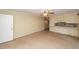 A large living room features neutral carpet, cream colored walls, and a partial view of the kitchen at 2320 Wofford Rd, Charleston, SC 29414
