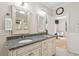 Well-lit bathroom featuring a double vanity, granite countertops, and an open doorway at 2645 Gnarled Pine, Seabrook Island, SC 29455