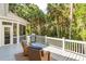 Outdoor deck with wicker chairs and a grill, nestled amongst lush tropical foliage and swaying palm trees at 2645 Gnarled Pine, Seabrook Island, SC 29455