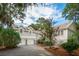 Charming home featuring a two-car garage, complemented by lush landscaping and beautiful crape myrtle trees at 2645 Gnarled Pine, Seabrook Island, SC 29455