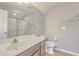 Well-lit bathroom featuring a white vanity top, wood-stained cabinets, and an enclosed shower at 271 Village Stone Cir, Summerville, SC 29486