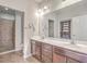 Well-lit bathroom features a double sink vanity and a walk-in shower with neutral tile and glass door at 271 Village Stone Cir, Summerville, SC 29486
