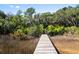A serene wooden dock stretches out over marshland towards the lake in the distance at 2725 Starfish Dr, Johns Island, SC 29455