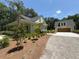Inviting home exterior with lush landscaping, long driveway and a detached garage at 2725 Starfish Dr, Johns Island, SC 29455