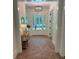 Inviting foyer with brick floors, stylish lighting fixture, and a glimpse of the outdoors through the glass front door at 2725 Starfish Dr, Johns Island, SC 29455