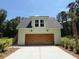 A detached, sage-colored garage with dark wood doors and a concrete driveway under a sunny sky at 2725 Starfish Dr, Johns Island, SC 29455