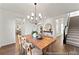 Elegant dining room with hardwood floors, a stylish chandelier, and staircase access at 279 Surf Bird Rd # 465, Summerville, SC 29486