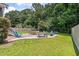 Landscaped backyard with a fire pit, seating, and a lush lawn area surrounded by trees at 3038 Penny Ln, Johns Island, SC 29455
