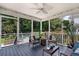 Relaxing screened porch with ceiling fan, seating area, and view of the lush backyard at 3038 Penny Ln, Johns Island, SC 29455