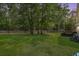Large backyard with mature trees, grassy lawn, and patio furniture at 307 Wilderland Ct, Moncks Corner, SC 29461