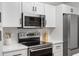 Close up view of a kitchen featuring stainless steel appliances, white cabinets, and black hardware at 307 Wilderland Ct, Moncks Corner, SC 29461