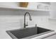 Modern kitchen sink with stainless steel faucet, white subway tile backsplash and white countertops at 307 Wilderland Ct, Moncks Corner, SC 29461