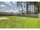 Wide shot of backyard with green grass and tall pines at 314 Sanctuary Park Dr, Summerville, SC 29486