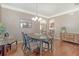 Stylish dining area featuring hardwood floors, a modern chandelier, and an open view to the kitchen at 314 Sanctuary Park Dr, Summerville, SC 29486