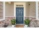 Inviting entryway featuring a blue front door flanked by potted plants and brick accents at 314 Sanctuary Park Dr, Summerville, SC 29486