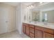 Main bathroom with dual sinks, wood cabinets, and a large mirror, offering a functional and stylish space at 314 Sanctuary Park Dr, Summerville, SC 29486