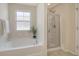 Bright bathroom with a bathtub, glass-enclosed shower, and a window for natural light, creating a relaxing atmosphere at 314 Sanctuary Park Dr, Summerville, SC 29486