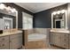 A luxurious bathroom featuring dual sinks, a soaking tub, and elegant fixtures and tile at 316 Bridgetown Pass, Mount Pleasant, SC 29464