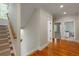 Bright hallway with hardwood floors leads to carpeted stairs and opens to another room at 316 Bridgetown Pass, Mount Pleasant, SC 29464