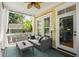 A cozy screened-in porch with wicker furniture, white curtains, and a ceiling fan at 316 Bridgetown Pass, Mount Pleasant, SC 29464