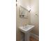 Stylish powder room featuring a pedestal sink with brass fixtures and framed mirror at 316 Bridgetown Pass, Mount Pleasant, SC 29464