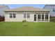 A neatly landscaped backyard with a green lawn and an enclosed porch at 316 Knawl Rd, Moncks Corner, SC 29461