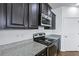 Modern kitchen features granite countertops, dark cabinets, stainless steel microwave, and electric stove at 316 Knawl Rd, Moncks Corner, SC 29461