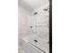 Modern bathroom features a shower over the tub with glass doors and marble look tiles at 327 Mcclain St, Charleston, SC 29407