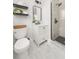 Stylish bathroom with walk-in shower, modern vanity, floating shelves, and marble tile flooring at 327 Mcclain St, Charleston, SC 29407