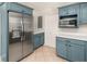 Updated kitchen features stainless steel appliances and blue cabinets with modern hardware and tile flooring at 327 Mcclain St, Charleston, SC 29407