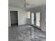 Bright living room with gray marble-like floors, a ceiling fan, and glass double doors at 3307 Londonderry Rd, North Charleston, SC 29420
