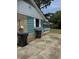 Exterior shot of a house with teal-painted wood planks, an electrical box, and black trash cans beside a concrete driveway at 3307 Londonderry Rd, North Charleston, SC 29420
