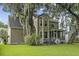Exterior view of the home highlighting the backyard with mature trees, a patio, and a screened-in porch at 3525 E Higgins Dr, Mount Pleasant, SC 29466