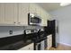 Kitchen with stainless steel appliances and dark countertops paired with white cabinetry at 3525 E Higgins Dr, Mount Pleasant, SC 29466