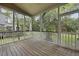 Screened-in porch with wood flooring, offering a serene view of the surrounding greenery at 3525 E Higgins Dr, Mount Pleasant, SC 29466