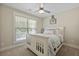 Cozy bedroom features a white-painted wooden bed, a ceiling fan, and a bright window at 3705 Sandy Gate Ln, Mount Pleasant, SC 29466