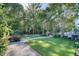 Lush backyard featuring a well-maintained lawn, mature trees, and a paved path leading to a tranquil outdoor retreat at 3751 St Ellens Dr, Mount Pleasant, SC 29466