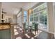 A sun-filled breakfast nook features large windows and a modern chandelier above the glass dining table at 3751 St Ellens Dr, Mount Pleasant, SC 29466