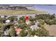 Overhead view of a home nestled among mature trees, with a glimpse of a bay in the background at 401 Ralston Creek St, Charleston, SC 29492